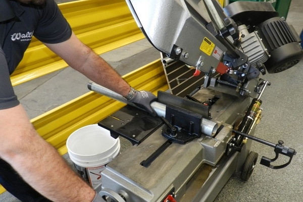 Technician using a pipe cutting tool to prepare electrical conduit for installation — showcasing precision in electrical fabrication and on-site utility setup.