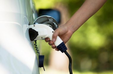 EV charging plug connected to electric vehicle for sustainable power distribution and clean energy use.