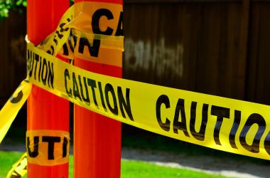 Yellow caution tape marking off jobsite hazard zone for electrical safety and protection.